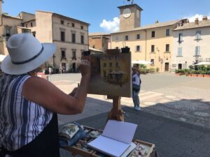 People outdoors painting a cityscape in Tuscany, Italy